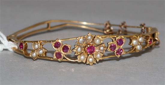 A seed pearl and gem set pierced gold hinged childs bangle.
